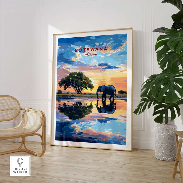 Botswana Elephant Sunset Art Print featuring an elephant by a serene water reflection.