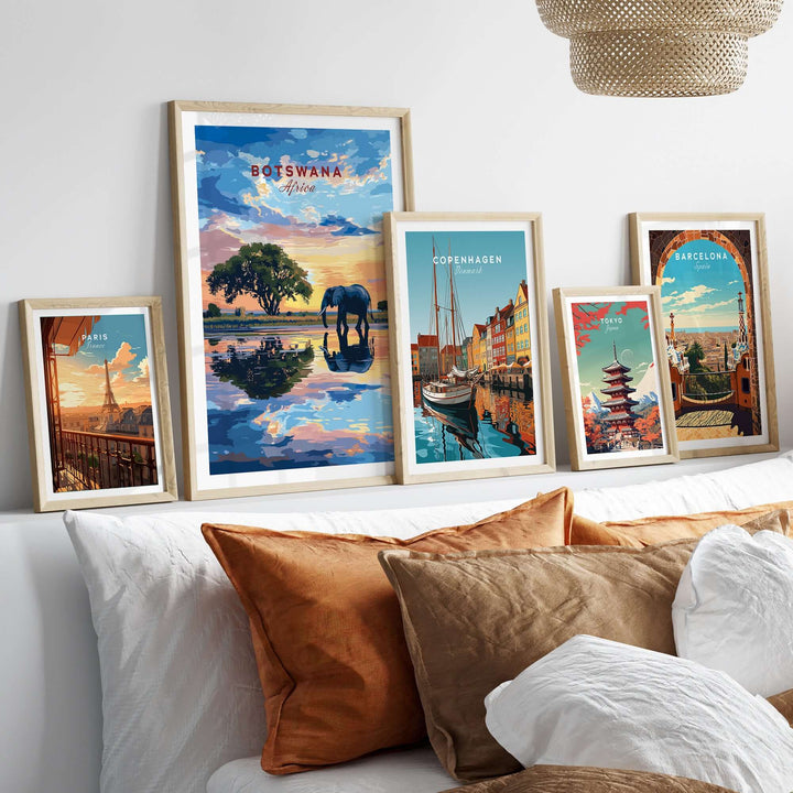 Framed Botswana elephant sunset art print with other city prints on a stylish bed arrangement.