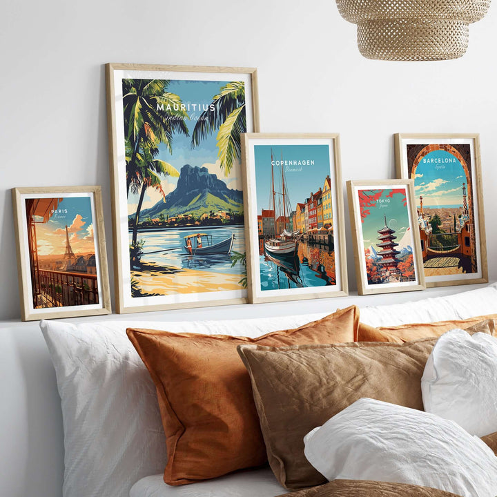 Framed travel posters featuring Mauritius, Copenhagen, and Barcelona above a stylish sofa with decorative pillows.