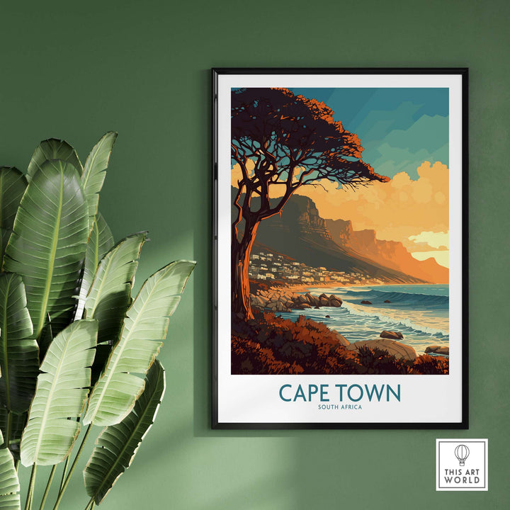 Cape Town poster featuring Camps Bay shoreline and mountain view, framed on a green wall with decorative foliage.