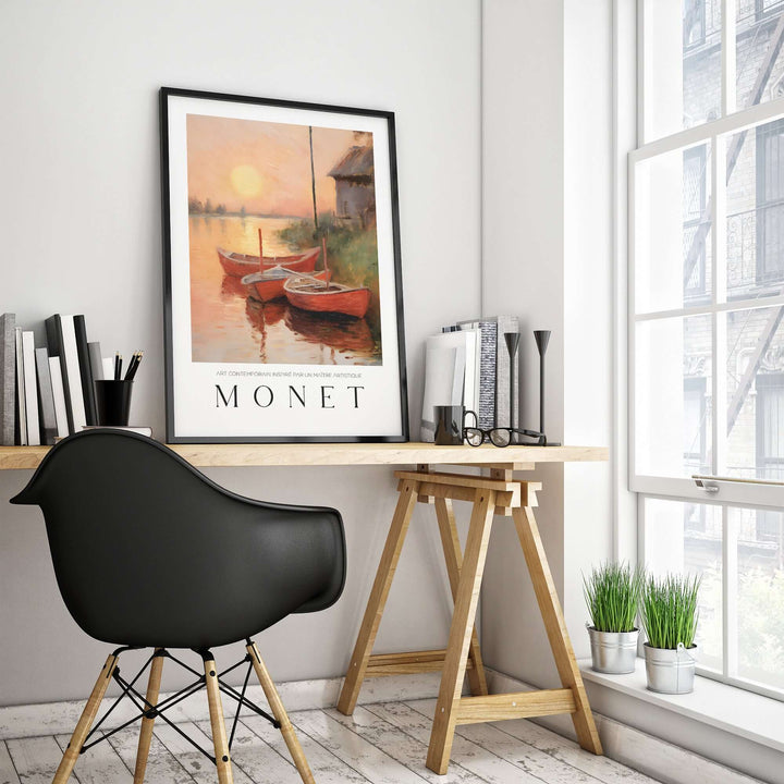 Claude Monet art print featuring red boats at sunset on a riverbank, displayed in a stylish workspace.