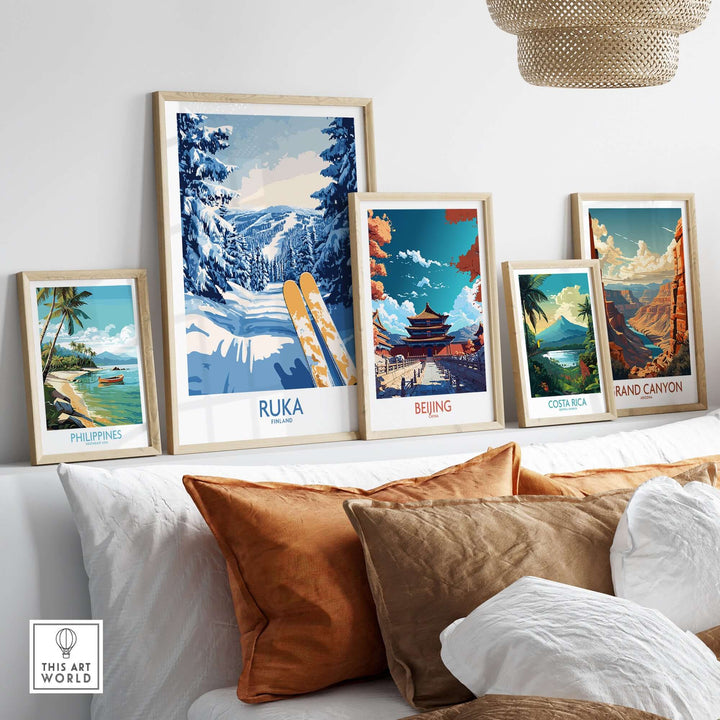 Framed travel posters including Ruka ski art, showcasing Nordic landscapes and tropical scenes on a cozy sofa display.