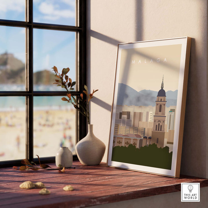 Malaga Travel Poster Print displayed on a wooden table with a beach view, showcasing minimalist design for modern decor.