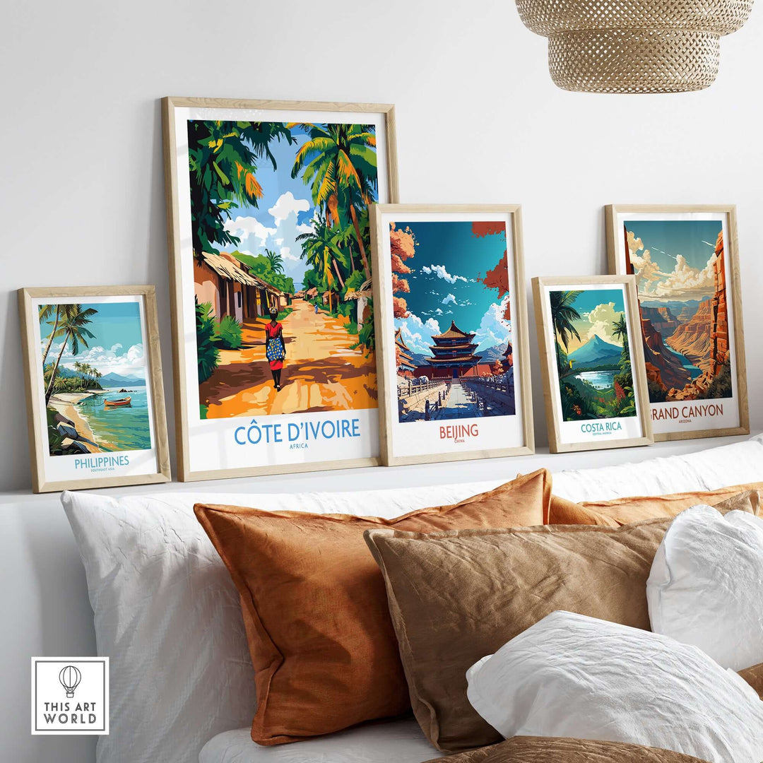 A collection of travel posters framed and displayed, featuring Côte d'Ivoire, Beijing, Costa Rica, and the Grand Canyon.