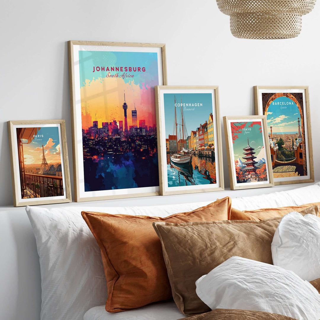 Johannesburg skyline poster and other cityscape prints displayed on a stylish bed with decorative pillows.