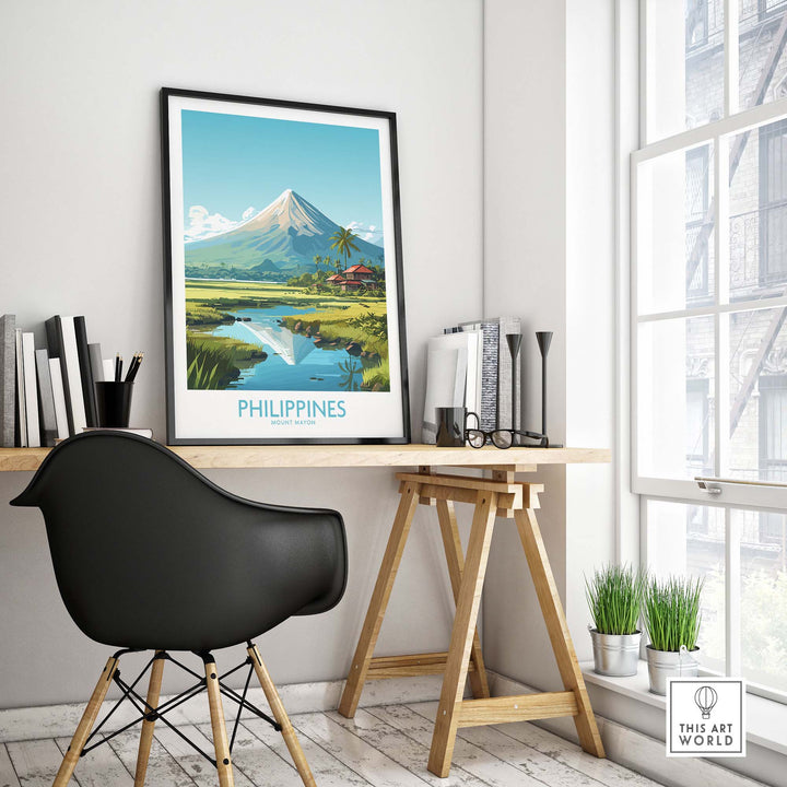 Modern travel poster of Mount Mayon, Philippines, displayed in a stylish workspace with a black chair and greenery.