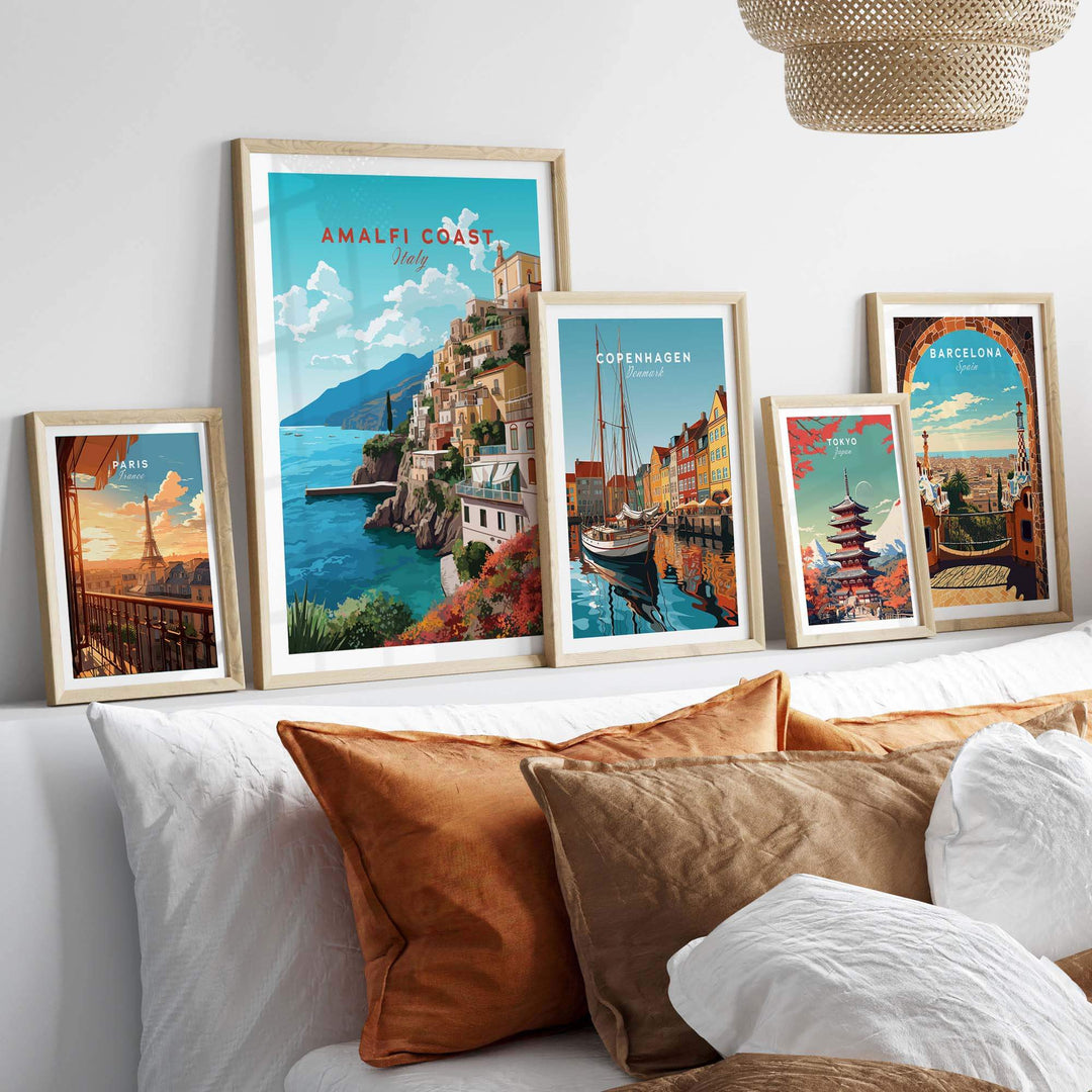 Amalfi Coast Travel Poster Print displayed alongside other city art prints on a cozy bed with cushions.