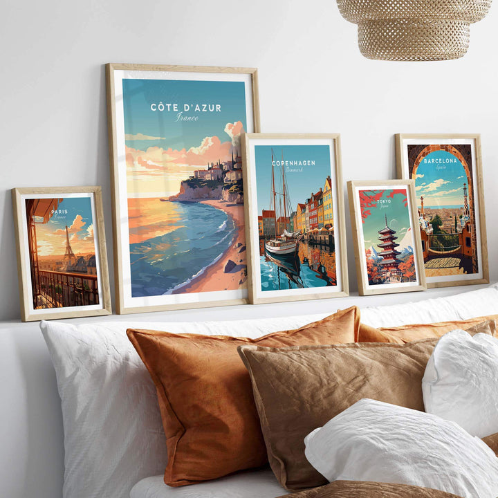 Colorful Côte d'Azur travel poster prints displayed on a cozy bed, enhancing wall art aesthetics.