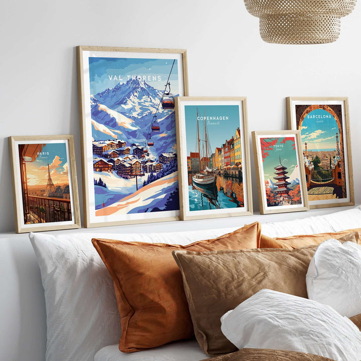 Val Thorens ski poster and travel prints on a wall above a cozy bed with brown pillows.