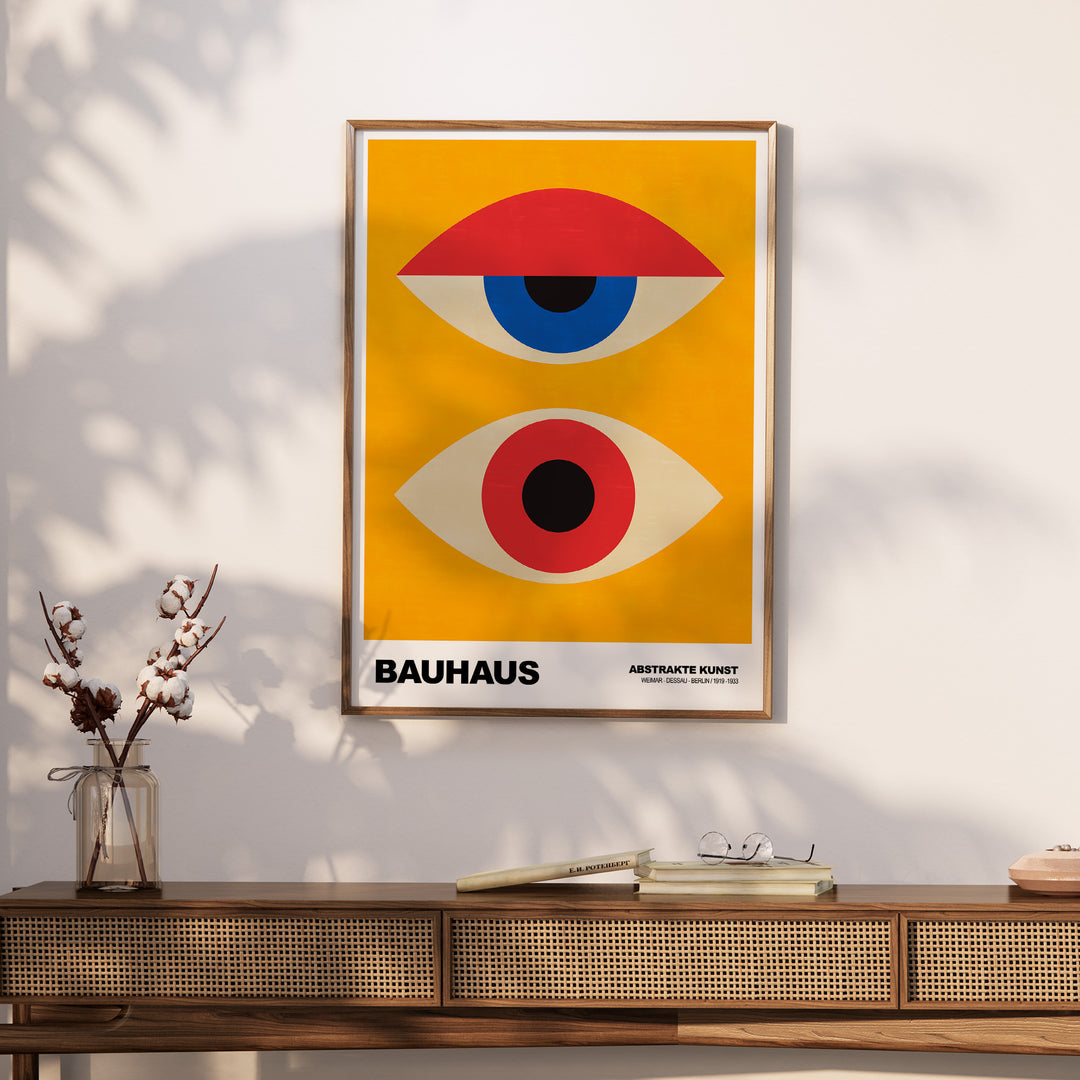 Bauhaus exhibition print featuring abstract eyes in geometric shapes against a vibrant yellow background.