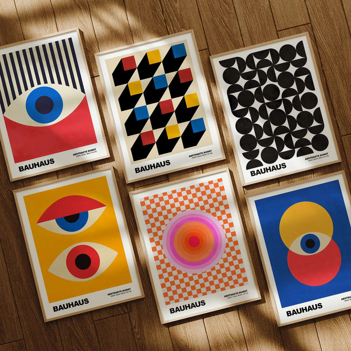 Bauhaus exhibition prints featuring geometric designs in circles, checkerboards, and bold colors on a wooden background.