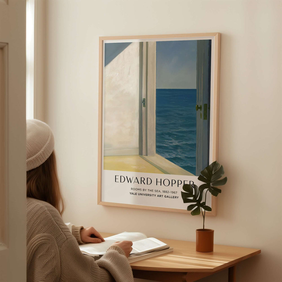 Edward Hopper Rooms by the Sea 1951 art print poster displayed in a cozy interior setting with a person reading.
