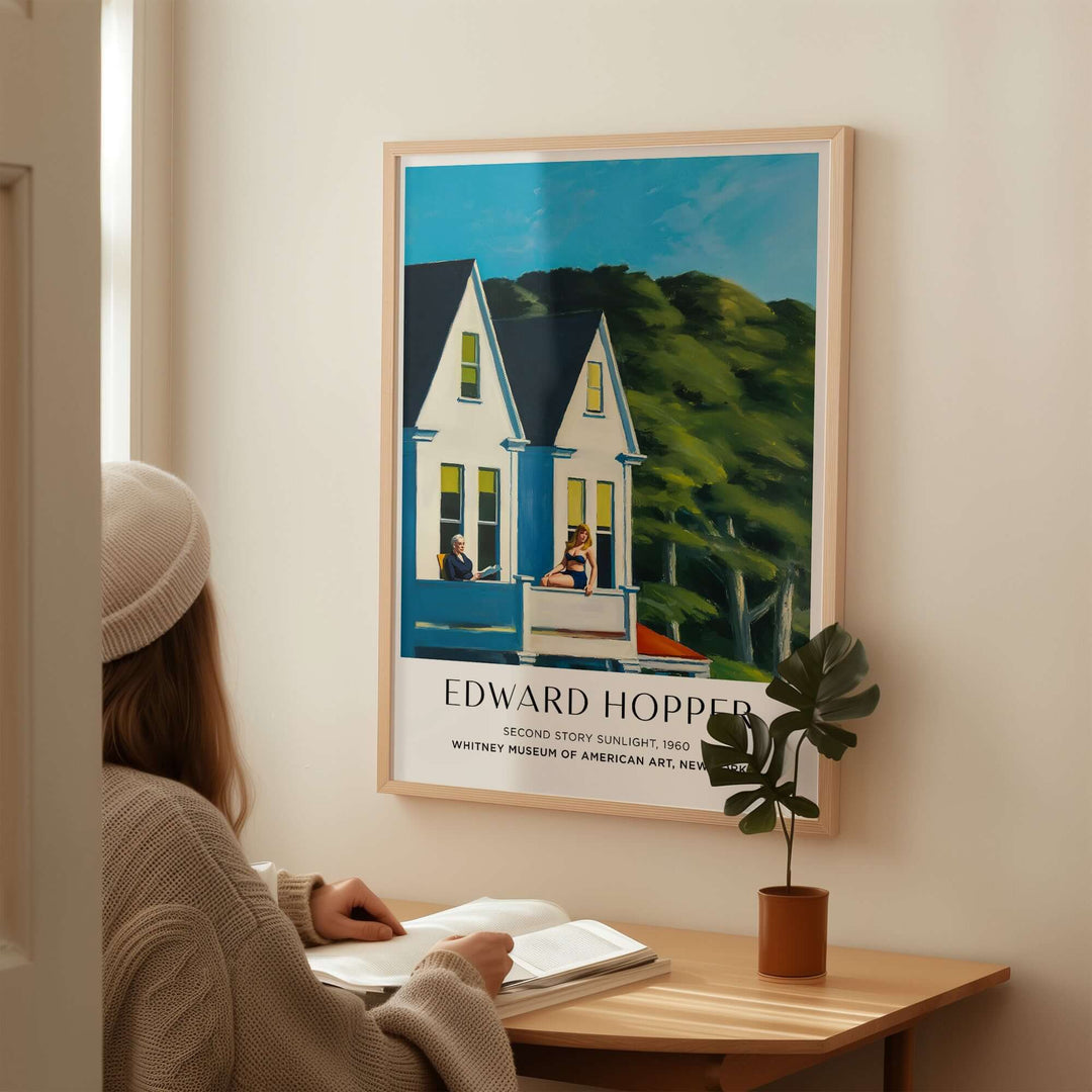 Woman admiring Edward Hopper's Second Story Sunlight 1960 art print in a cozy room setting.