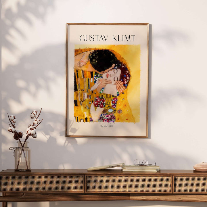 Gustav Klimt art print 'The Kiss' (1907) displayed on a wall above a stylish wooden table.