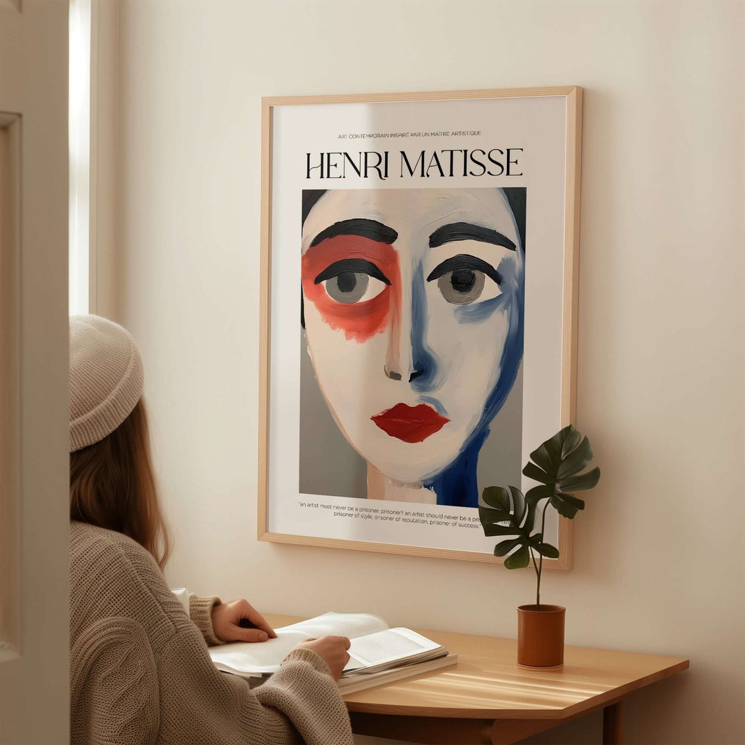 Matisse-inspired abstract face portrait print on wall, with person studying nearby. Bold colors and striking features.