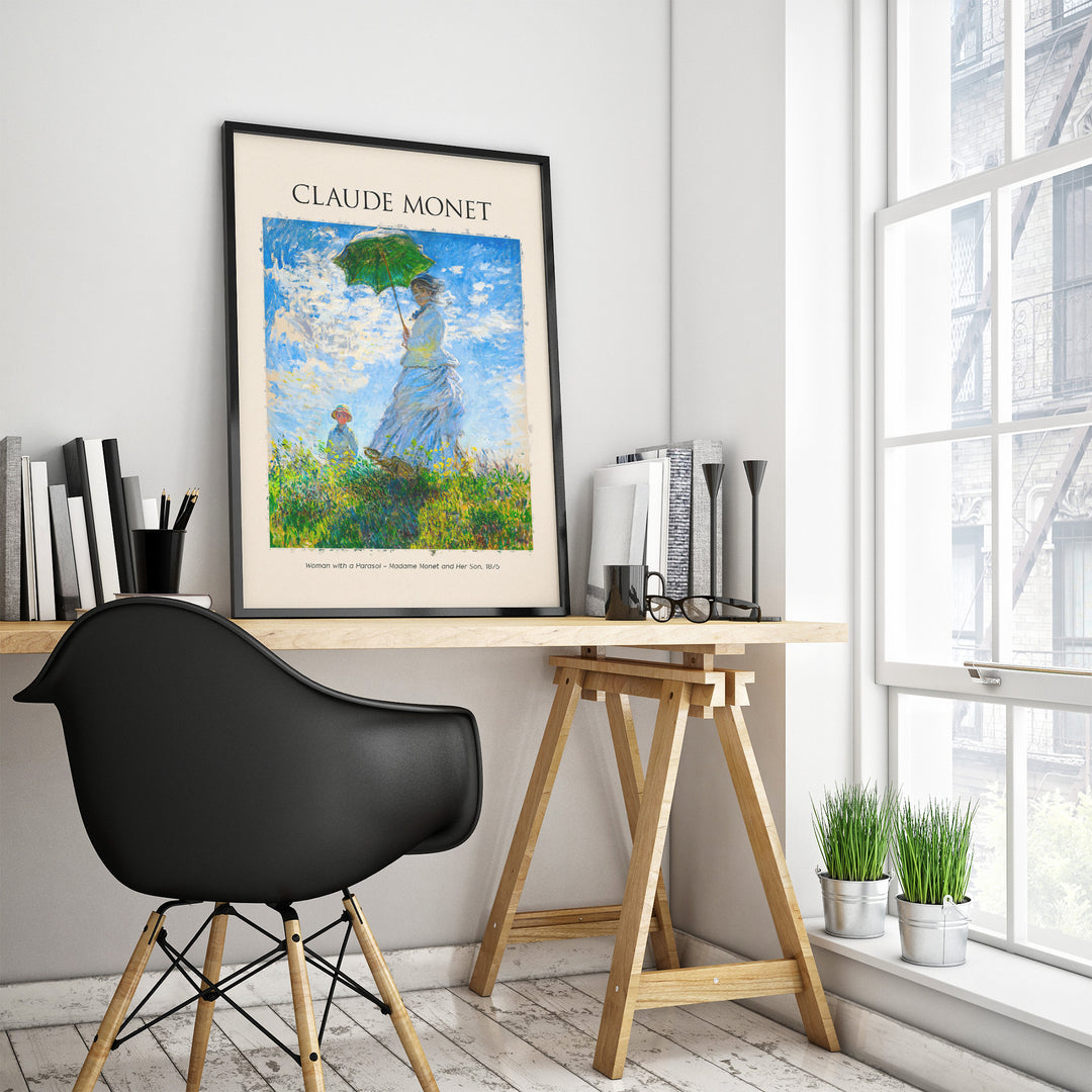 Claude Monet 'Woman with a Parasol' art print displayed in a modern workspace with a black chair.
