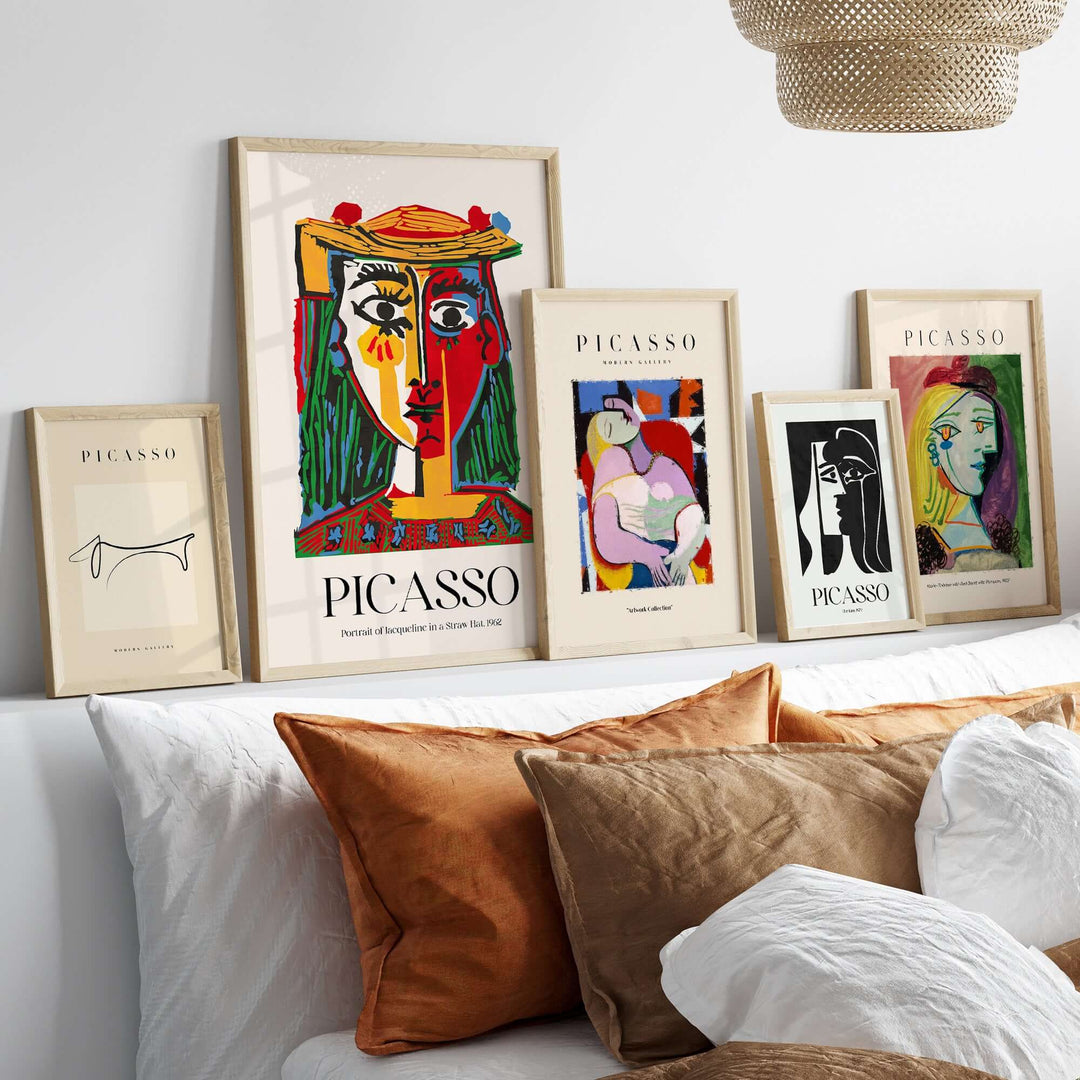 Gallery display of Picasso abstract art prints and portraits on a stylish white shelf with decorative pillows.