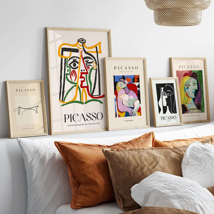 Colorful Picasso art prints displayed in frames on a wall, featuring abstract line art and portraits.