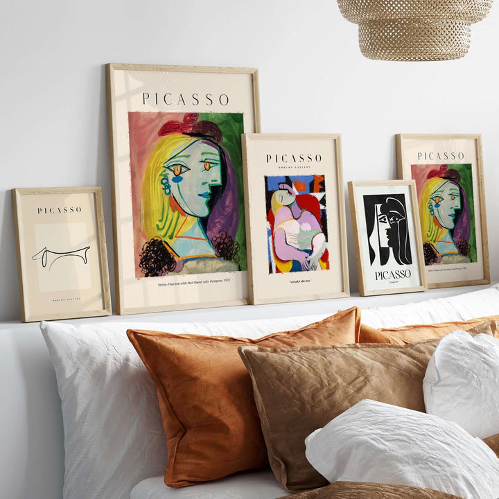 Collection of framed Picasso art prints featuring vibrant colors and Cubist themes, displayed on a modern shelf.