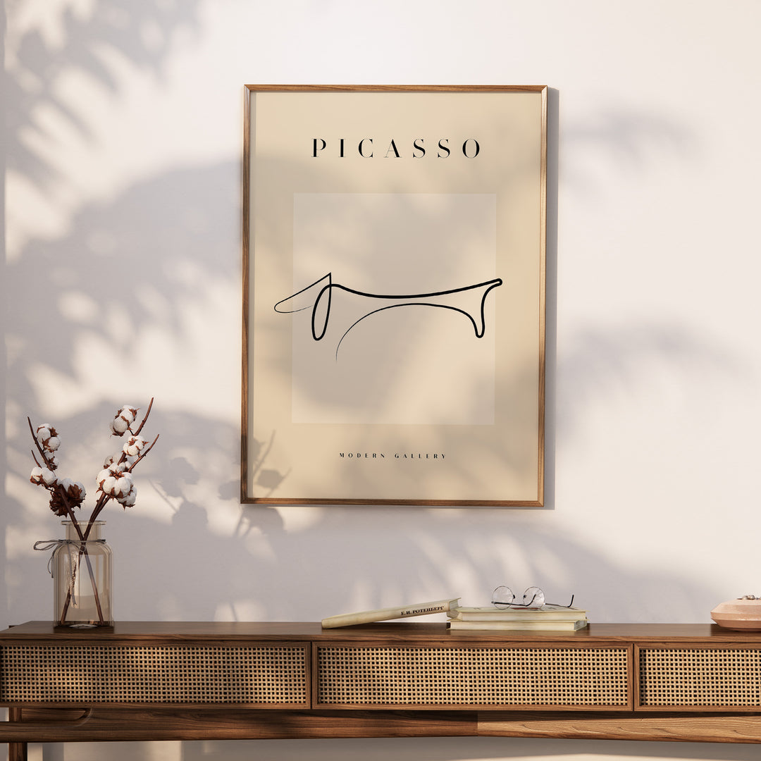 Minimalist Dachshund line art print in Picasso style, framed and displayed in a modern gallery setting.