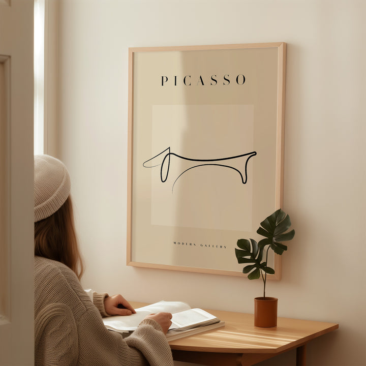 Minimalist line art poster of a Dachshund by Picasso, displayed in a cozy interior setting.