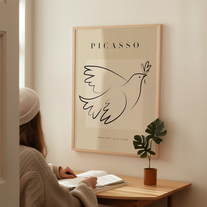 Minimalist Picasso Dove of Peace line art poster in a modern gallery setting, featuring elegant black lines on a beige background.