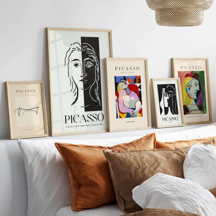 Framed Picasso art prints featuring various styles on a modern shelf with decorative pillows.