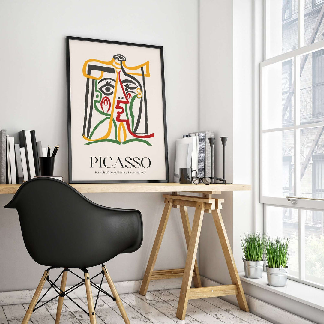 Colorful Picasso abstract wall art print in modern workspace with black chair and plants.