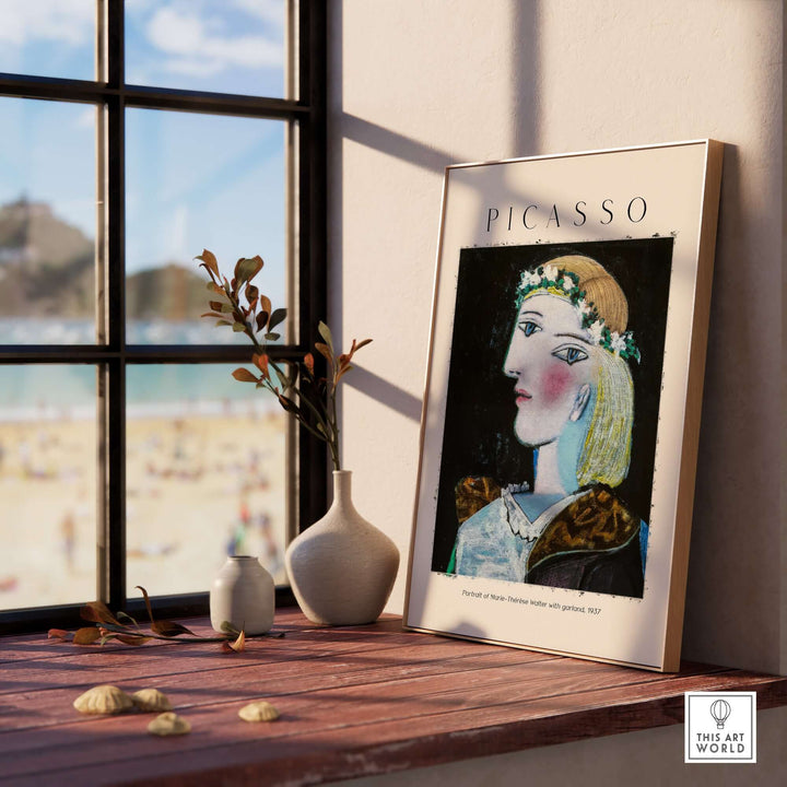 Picasso portrait of Marie-Thérèse Walter with garland, 1937 art print displayed on a wooden table near a window.