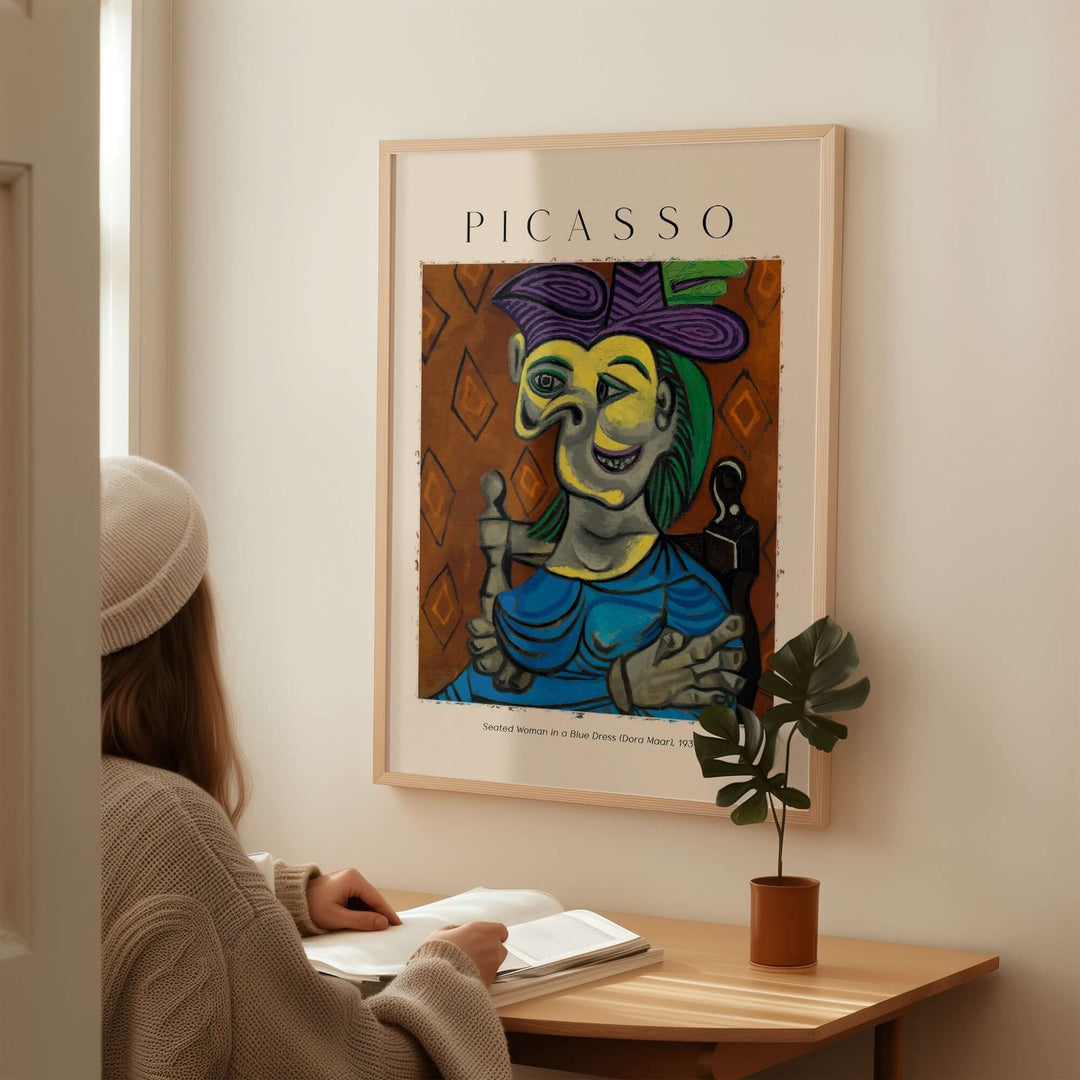 Woman admiring Picasso's 'Seated Woman in Blue Dress (Dora Maar)' print, featuring Cubist art with vibrant colors.