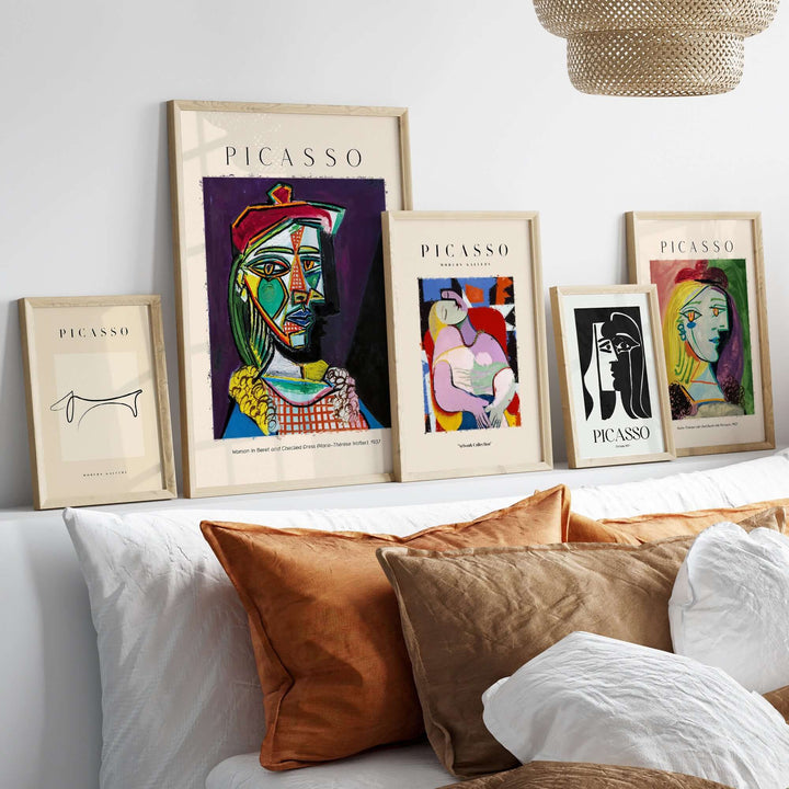 Collection of Picasso framed art prints displayed on a shelf, featuring vibrant abstract styles and colors.