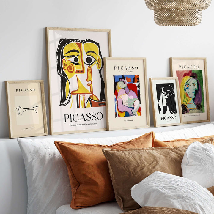 Collection of Picasso art prints featuring stylized portraits on a stylish shelf with decorative pillows.