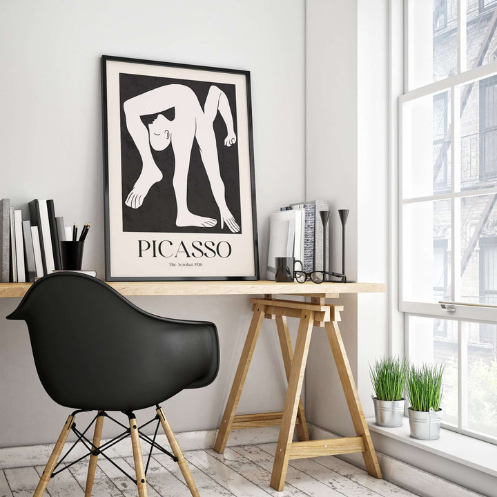 Minimalist art print of Picasso's 'The Acrobat' (1930) displayed in modern workspace with black chair and wall decor.