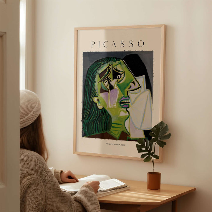 Person admiring Picasso's Weeping Woman 1937 art print on wall, showcasing emotional cubist portrait in living space.