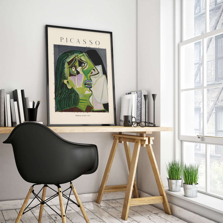 Picasso Weeping Woman 1937 art print displayed in a modern office setting with black chair and wooden desk.
