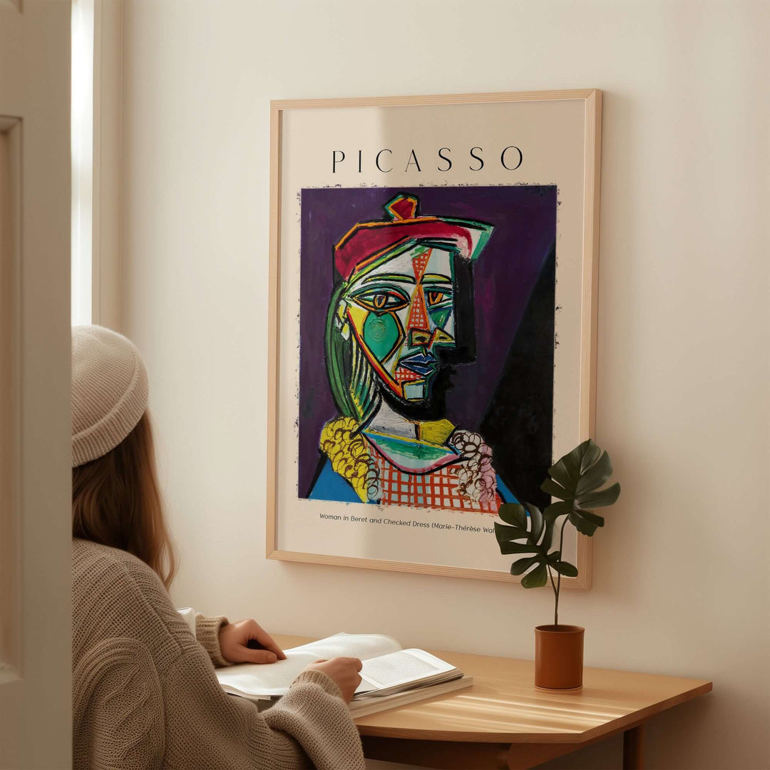 Woman sitting at desk admiring Picasso 1937 Cubist portrait poster of Marie-Thérèse in beret and checked dress.