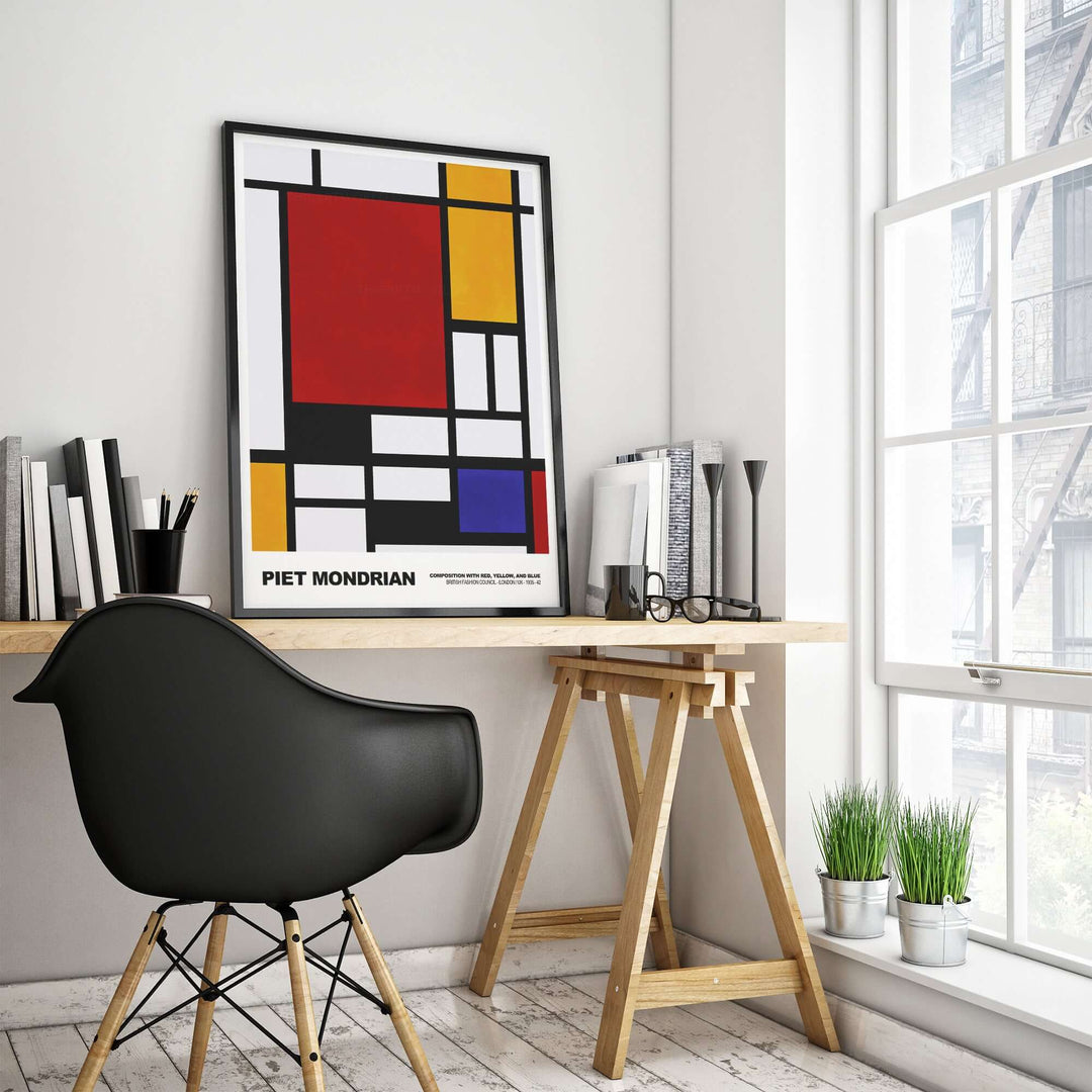 Piet Mondrian Composition Red Yellow Blue poster on a desk with a black chair and bookshelves in a modern room.