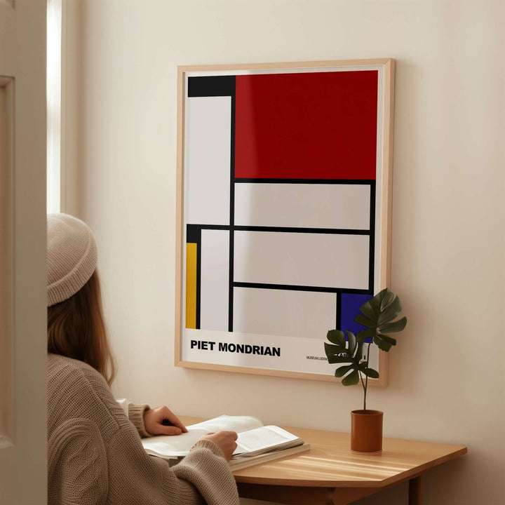 Piet Mondrian Tableau I 1921 poster displayed on wall, featuring abstract geometric design in primary colors.