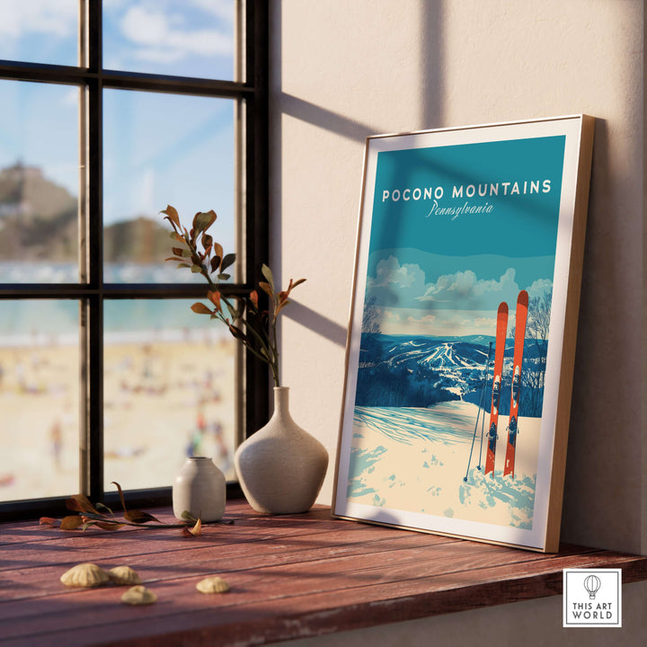 Pocono Mountains ski resort poster featuring winter sports scenery, displayed on a stylish table by a window.