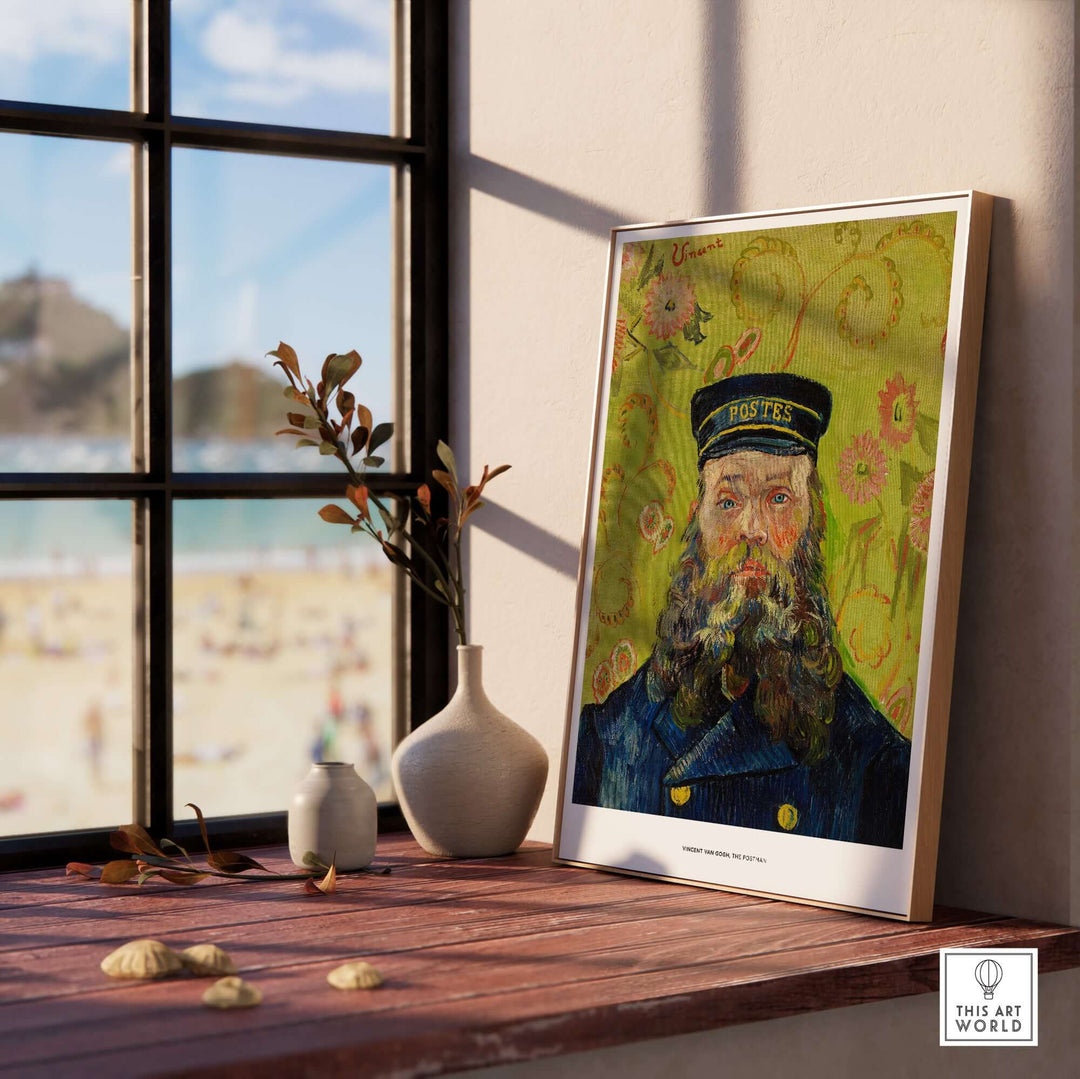 Framed Vincent van Gogh 'The Postman' portrait art print displayed on a wooden table with beach view.