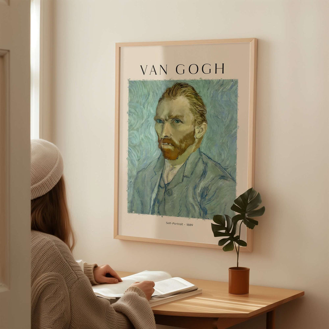 Woman sitting at a table viewing a framed Vincent van Gogh Self-Portrait art print on the wall.