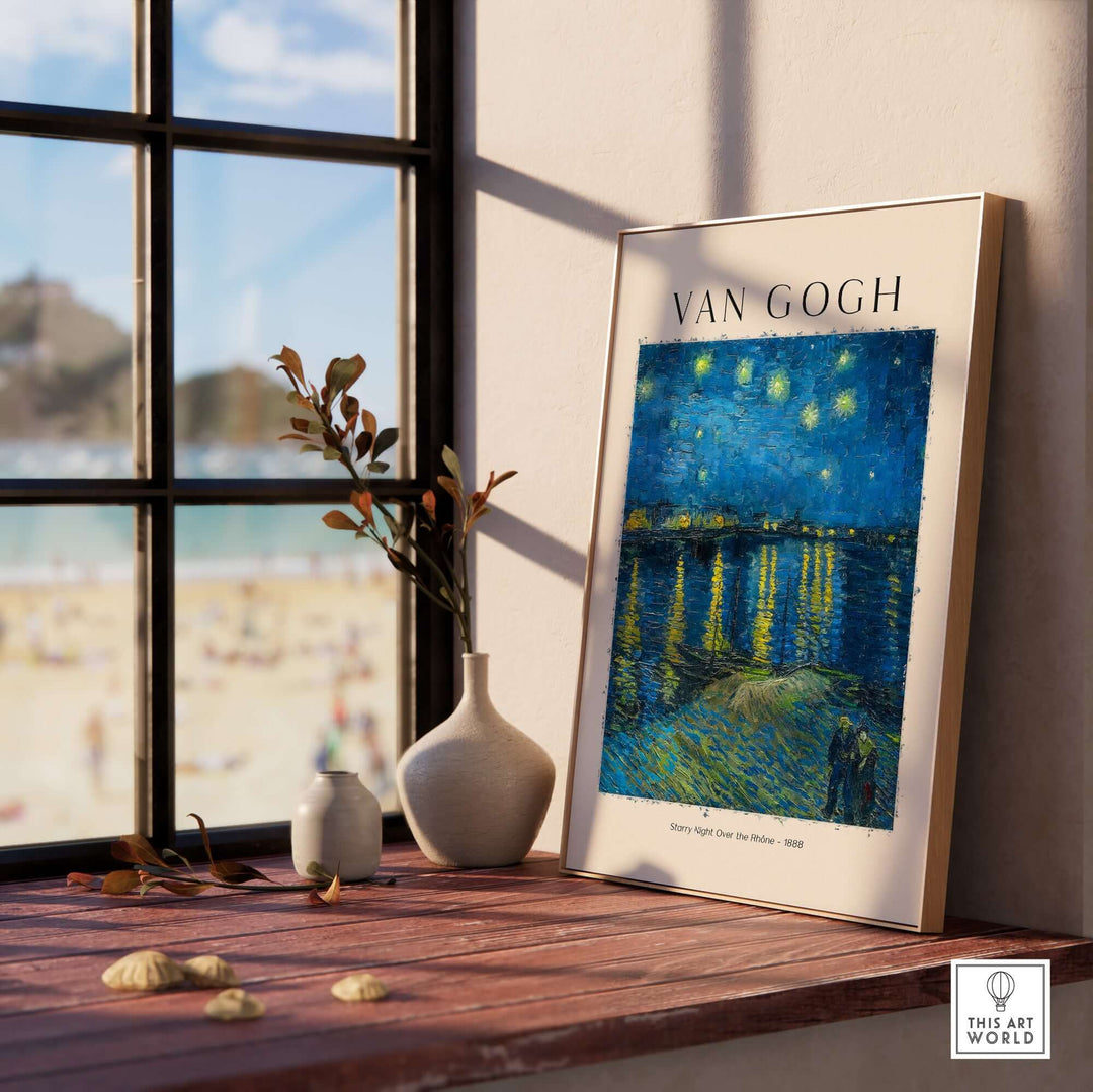 Framed Vincent van Gogh Starry Night Over the Rhône poster print on a windowsill with beach view.