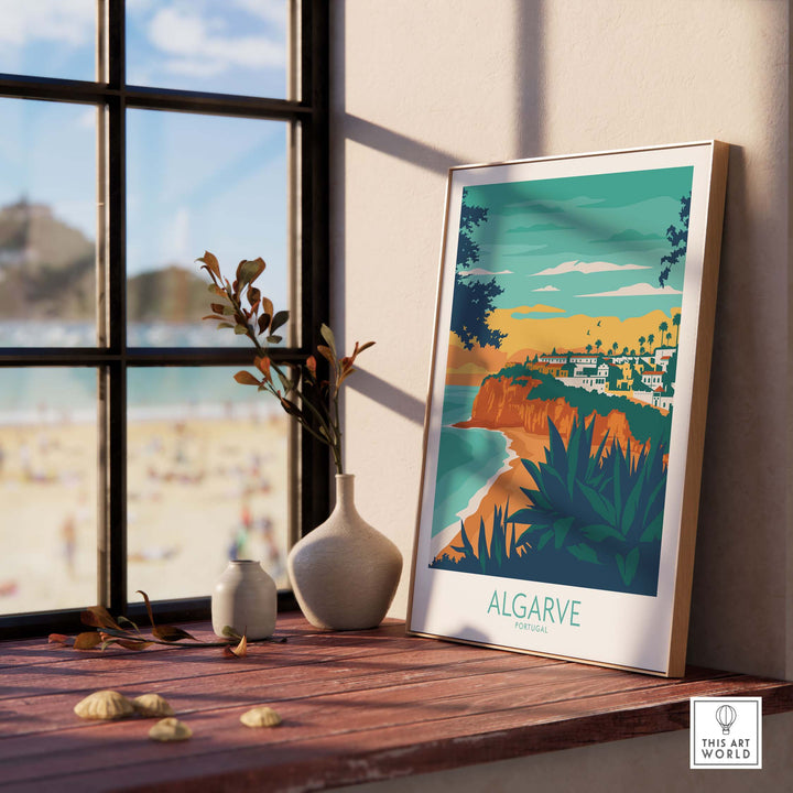 Algarve Print Portugal framed on a wooden table, showcasing coastal scenery and inspired vintage travel art.