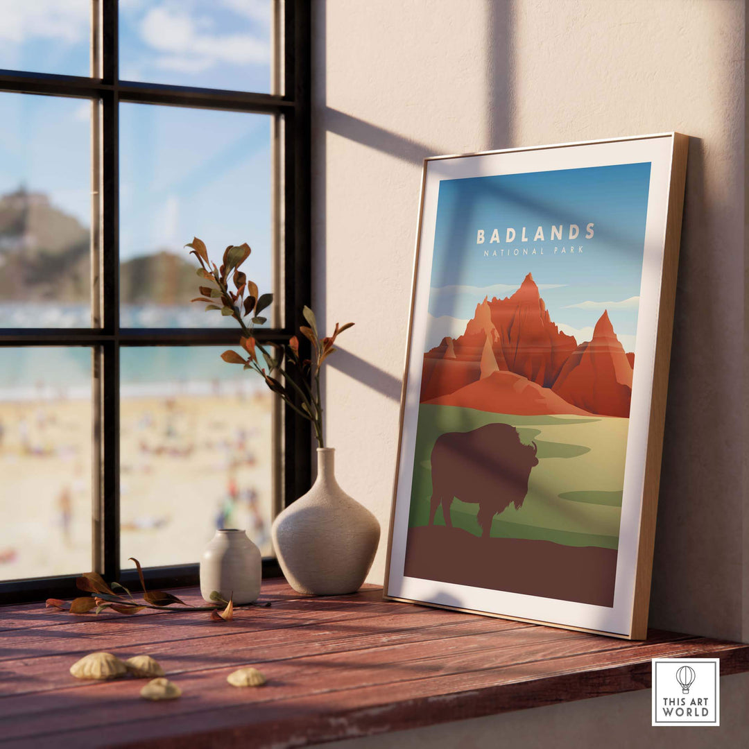 Framed Badlands National Park art print featuring iconic landscapes and a bison, displayed by a window.
