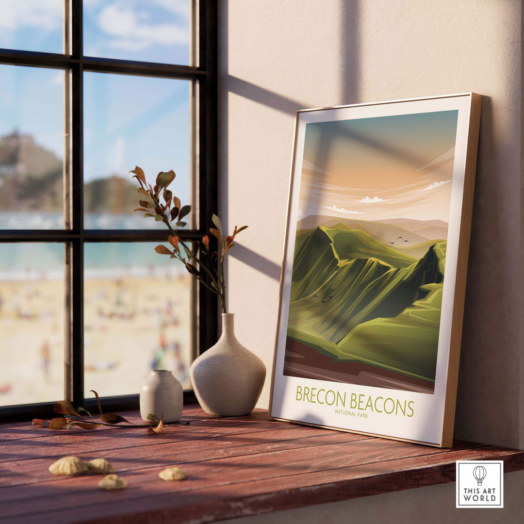 Brecon Beacons National Park Poster art print displayed on a wooden shelf with a modern vase and beach view in the background.