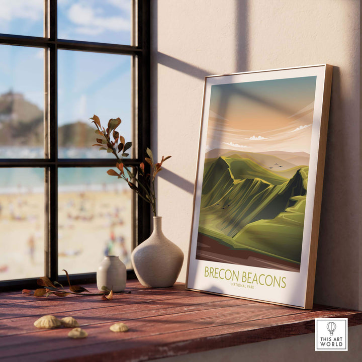 Brecon Beacons National Park Poster art print displayed on a wooden shelf with a modern vase and beach view in the background.