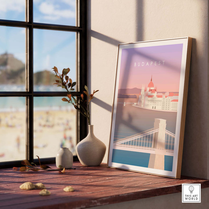 Budapest Print Wall Art Poster in a stylish frame on a wooden table with natural decor and a beach view.