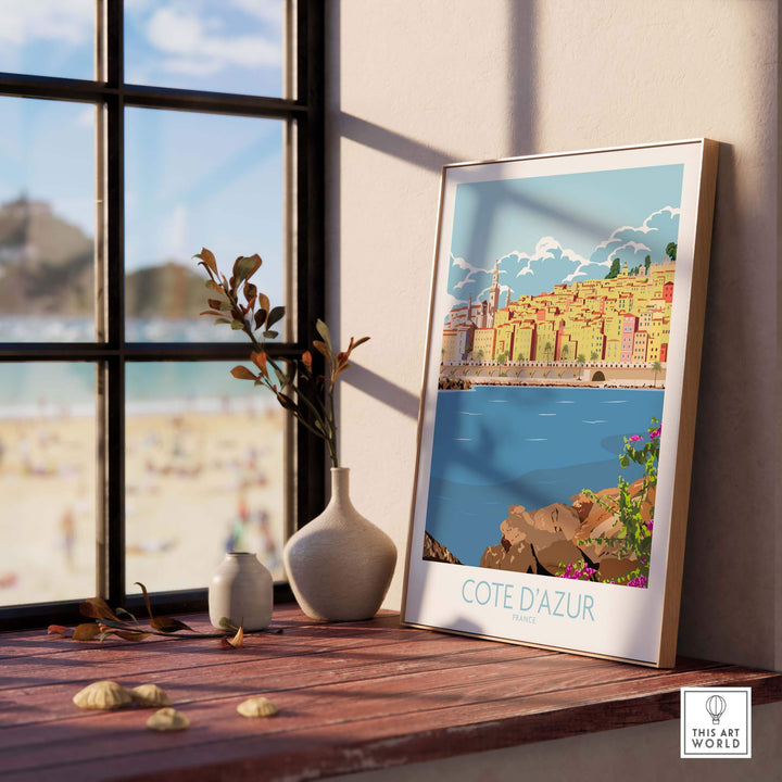 Cote d'Azur print poster displayed indoors by a window, capturing vintage travel art vibes and modern decor.