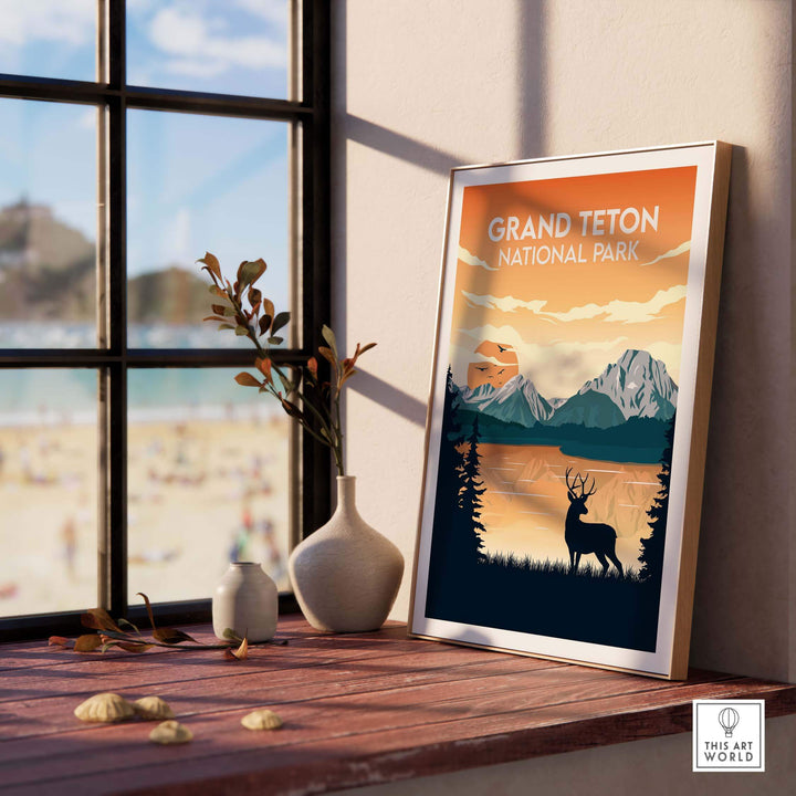 Framed Grand Teton National Park poster on a wooden table showcasing mountains and a deer, perfect for nature lovers.