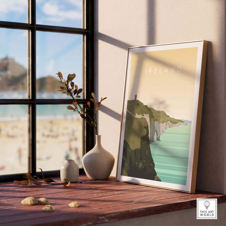 Ireland wall art travel poster framed on a windowsill, showcasing coastal cliffs and scenic views.